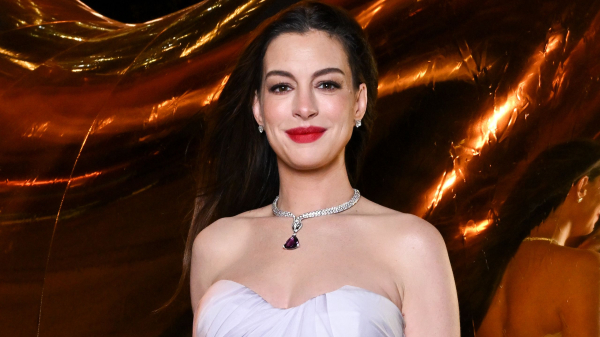 Anne Hathaway wears red lipstick and nail polish with a strapless palelilac gown and necklace.